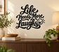 Vinyl wall decal with 'Life Needs More Laughs' script and smiley face