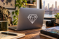Diamond outline facets vinyl decal on matte laptop lid, geometric diamond icon in white