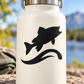 Vinyl decal of a leaping fish over a wave, black design on light surface