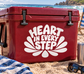 Vinyl decal with "HEART IN EVERY STEP" lettering and heartburst design on red surface