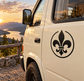 Open-circle fleur-de-lis vinyl decal, black crest on a vehicle door panel