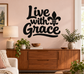Black vinyl wall decal reading “Live with Grace” with fleur-de-lis accent
