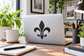 Black fleur-de-lis vinyl decal on laptop lid