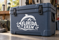 White Florida Crew vinyl decal with dolphin and ocean wave accents on a blue cooler