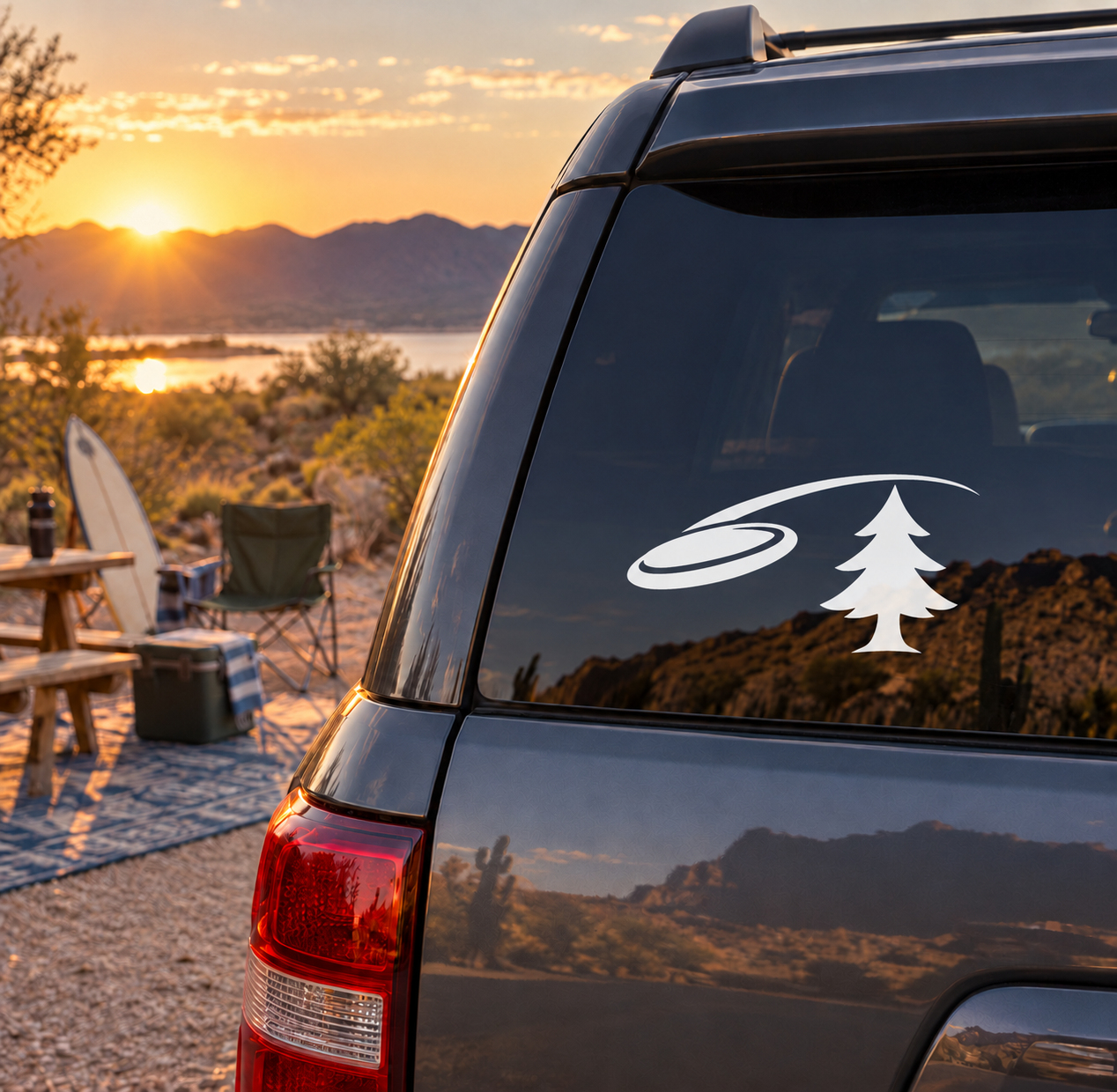 Flying disc and pine tree vinyl decal on dark car rear window