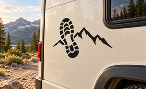 Black vinyl decal of boot footprint and mountain ridge on a vehicle panel