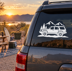 Mountain road vinyl decal with white SUV, pine trees, and mountain range on a car window
