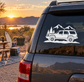 Mountain road vinyl decal with white SUV, pine trees, and mountain range on a car window
