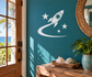 Glow-in-the-dark vinyl decal of rocket on crescent moon with stars