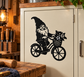 Black gnome vinyl decal riding a bicycle with flower basket on a cabinet door.