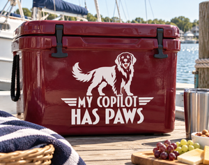 Vinyl decal of a golden retriever with wings and the text “My Copilot Has Paws”.