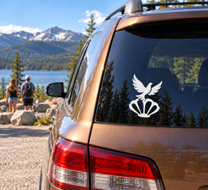 Vinyl dove and shell decal on car rear window, white graphic against dark tint
