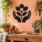 Black vinyl wall decal of hands holding a flower with peach center