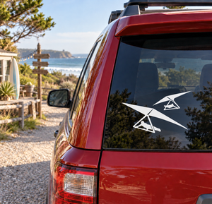 Hang gliding twin-wing vinyl decal on car window, white glider icons on dark glass