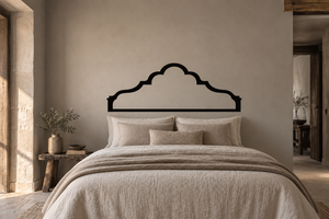 Quatrefoil crown vinyl wall decal above a bed headboard, black outline silhouette