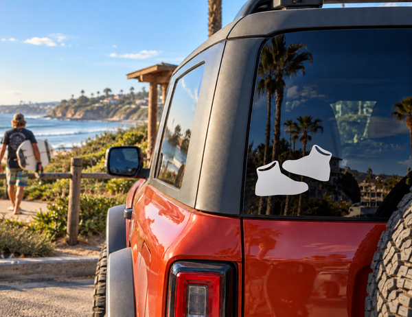 Street sneaker vinyl decal pair on car window: two black shoes with white outlines