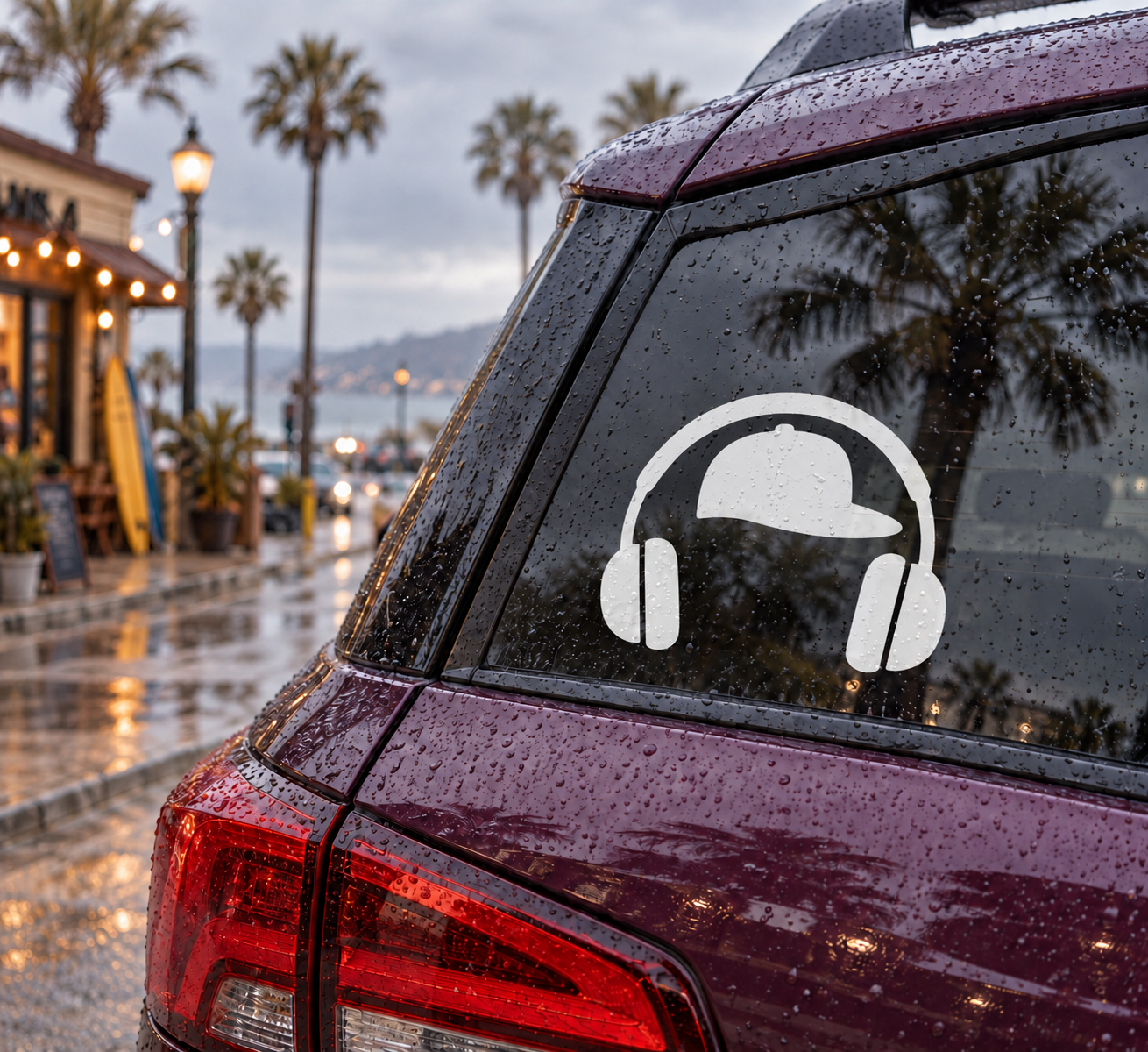 Vinyl decal of black headphones and cap on a car window