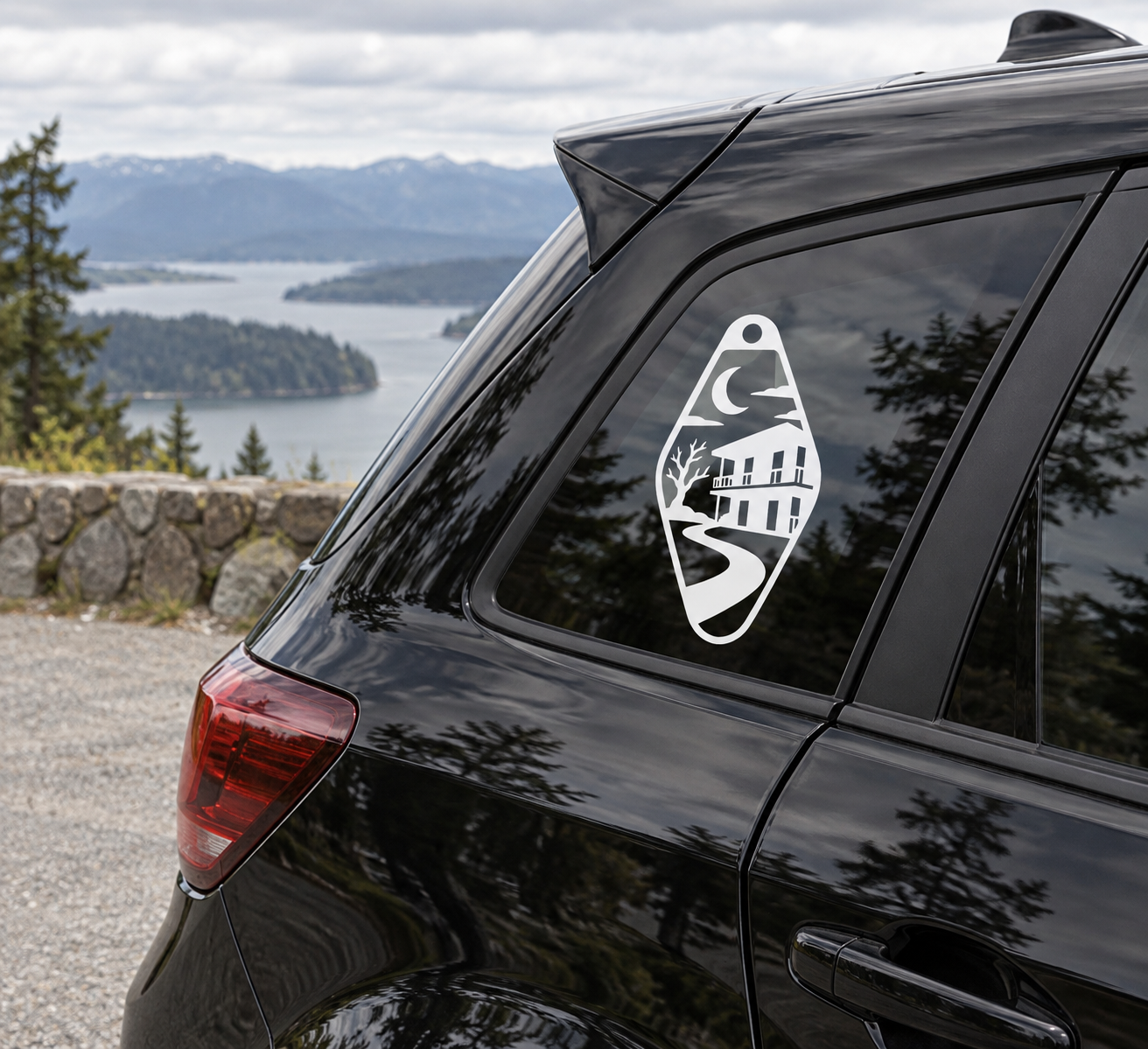 Spooky motel key vinyl decal with moon house silhouette, shown on car window
