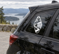 Spooky motel key vinyl decal with moon house silhouette, shown on car window