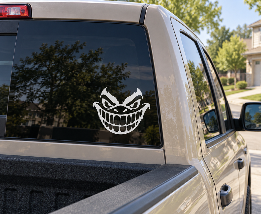 Grinning monster vinyl decal on car window, white and black cartoon face