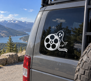 Ghost and film reel vinyl decal on vehicle window, white and black design