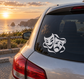 Pair of vinyl horror mask decals on car window, white faces on dark surface