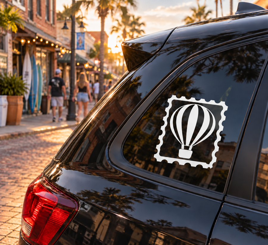 Hot air balloon stamp vinyl decal on dark car window, white balloon icon in black circle
