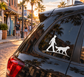 Vinyl decal of hunter with dog silhouette on car rear window