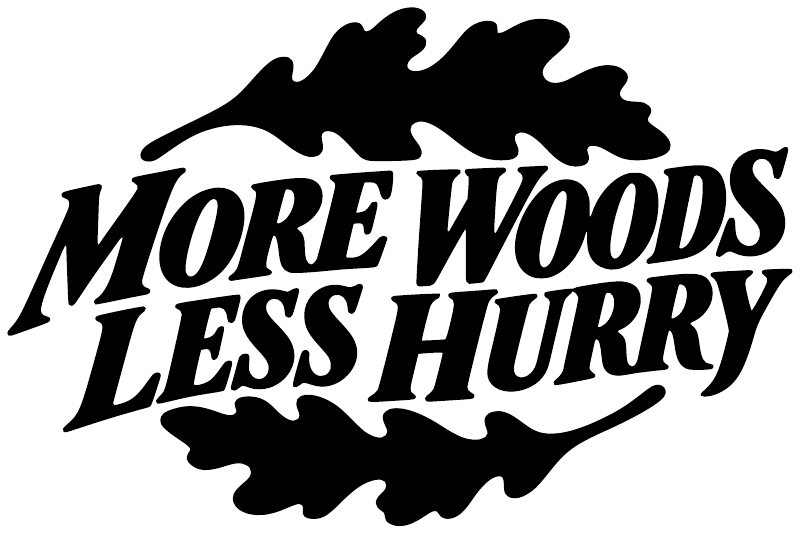 White 'More Woods Less Hurry' lettering with dark tree silhouette vinyl decal