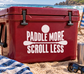 Red cooler vinyl decal: “PADDLE MORE SCROLL LESS” with paddle icon
