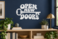 White vinyl wall decal reading "OPEN NEW DOORS"