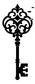 Close-up of ornate black skeleton key wall decor with scrollwork and leaf cluster top