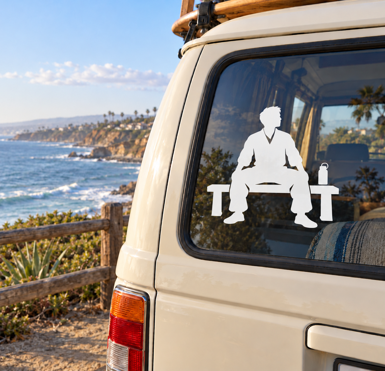 White vinyl decal of seated kung fu fighter with large “T” and bottle on car window
