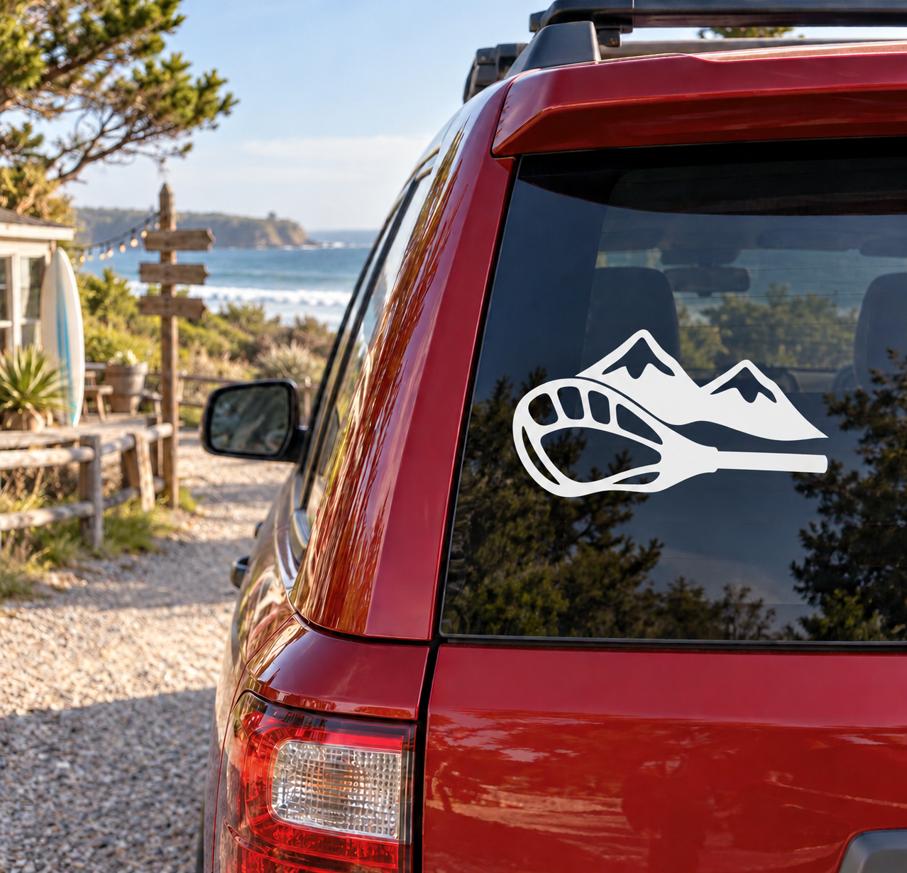 Red car rear window with white mountain and lacrosse stick vinyl decal