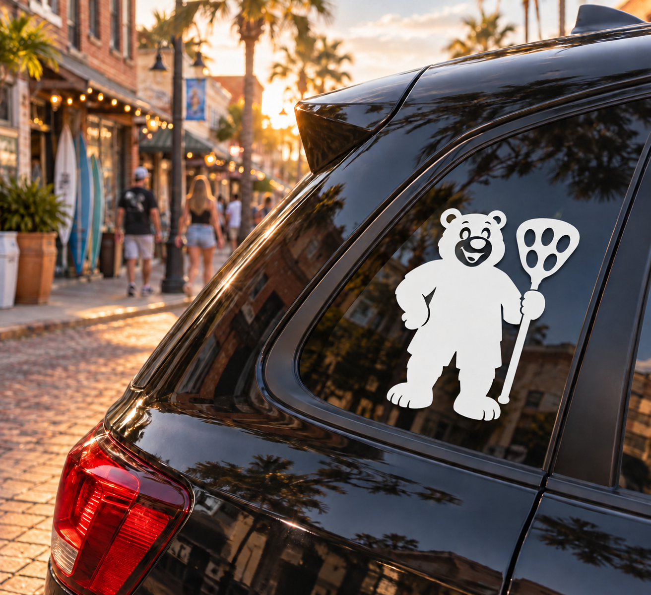 Goalie lacrosse bear vinyl decal on car window; black bear holding a stick and lacrosse head