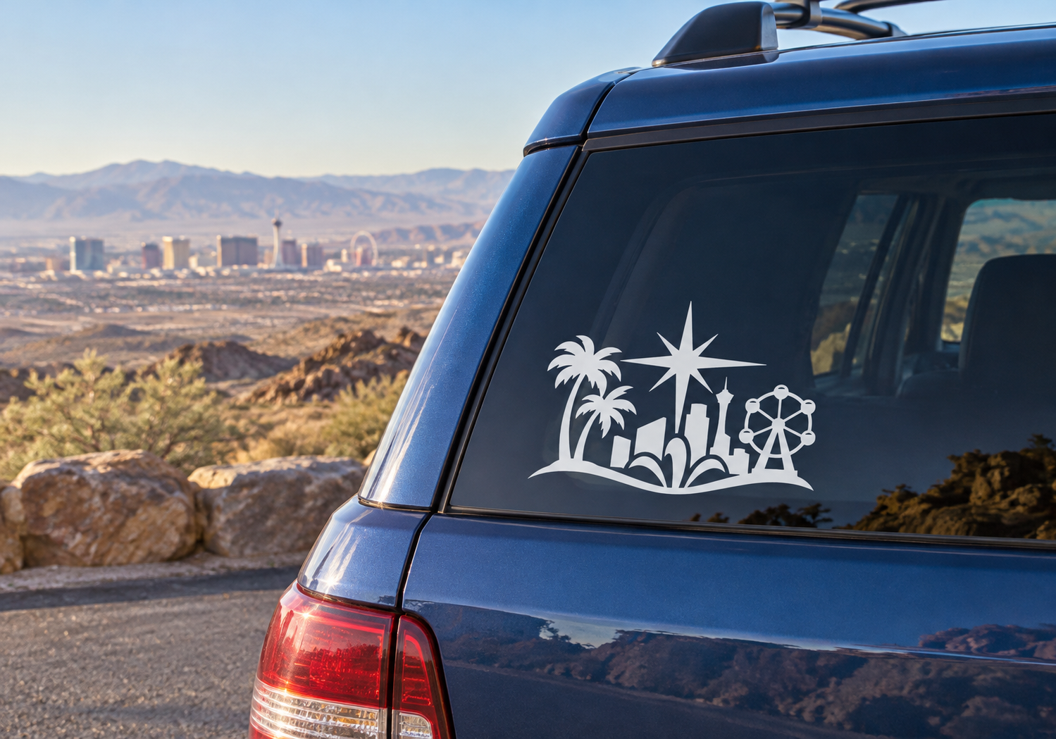 Black vinyl decal of desert skyline with palm trees, starburst, and atomic-style wheel on car glass