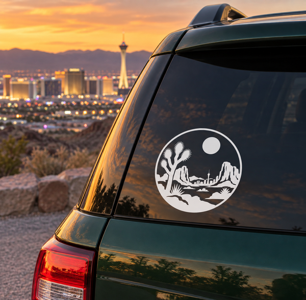 Round white vinyl decal with desert skyline, cactus, and moon on car window