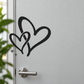 Black interwoven hearts door decal with flowing tails and three star spark marks