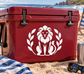 Vinyl lion medallion decal with laurel leaves on a red cooler lid