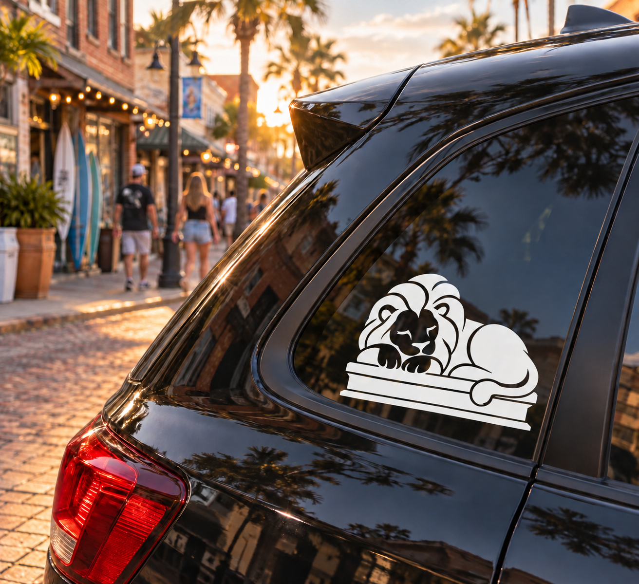 White sleeping lion vinyl decal on car window, paw resting on a stone ledge