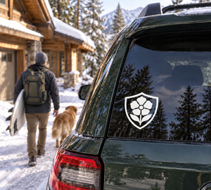 Shield-shaped vinyl decal with black rose-like flower crest on a vehicle window