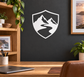 Vinyl shield decal with white outline and black-and-white mountain landscape graphic