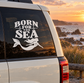 Black "BORN FOR THE SEA" mermaid vinyl decal with anchors on car window.