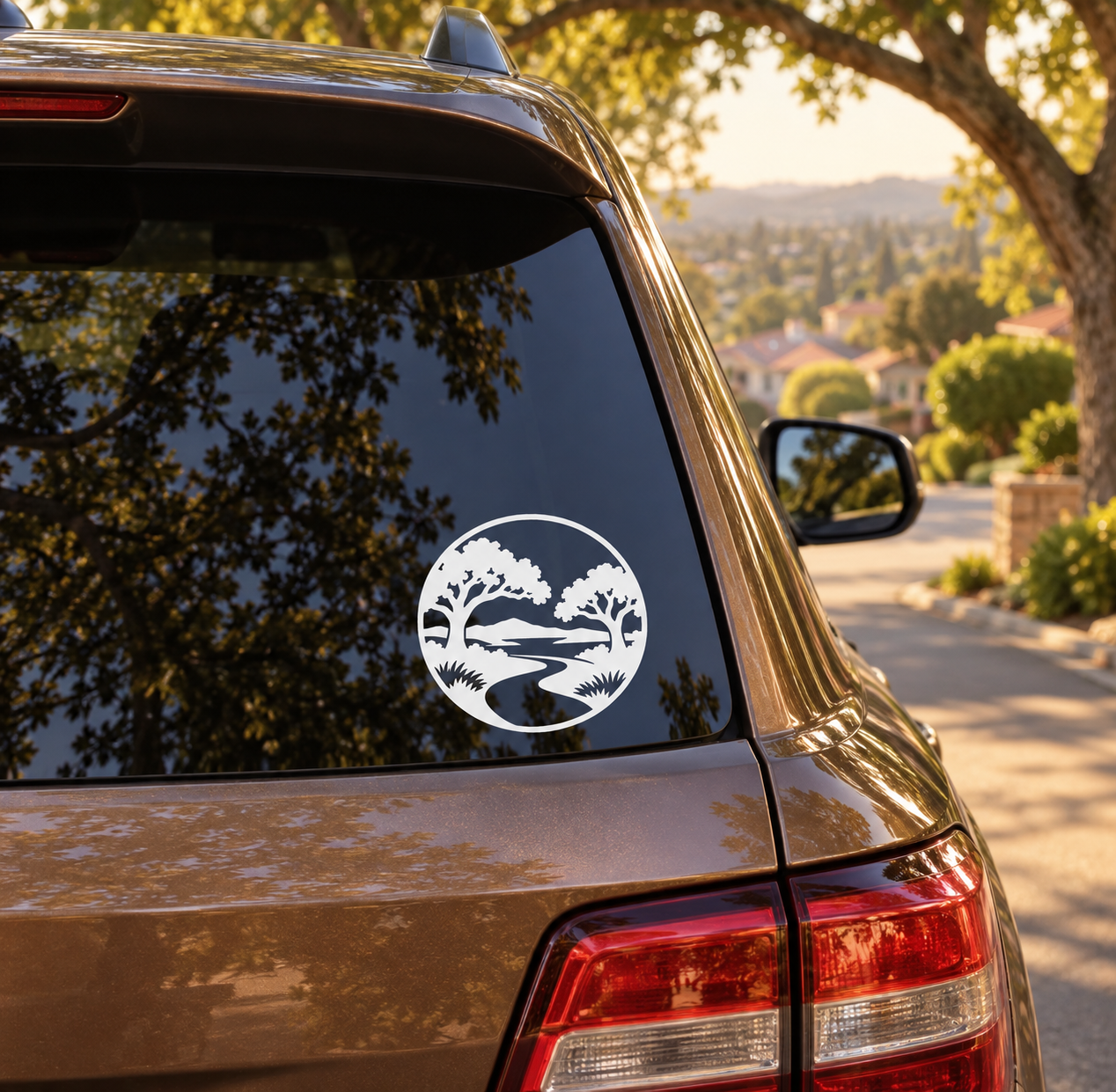 Round black-and-white vinyl decal with trees and landscape scene on car window