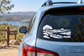 Vinyl car decal featuring black landscape silhouette with tree, hills, fence, and sun