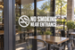 No smoking near entrance vinyl decal with no-smoking symbol and wide text
