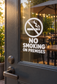 No smoking on premises vinyl decal with cigarette icon and stacked text on glass door