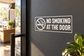 Corner frame vinyl decal with “No Smoking at the Door” warning sign on a wall