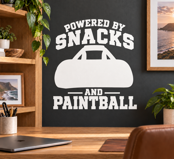 Black-and-white paintball vinyl decal reading “POWERED BY SNACKS AND PAINTBALL”