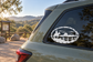 Oval vinyl decal with cowboy riding horse, fence and landscape silhouette in black